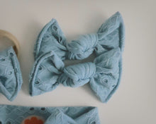 Light blue scrunchie with lace details on a white background