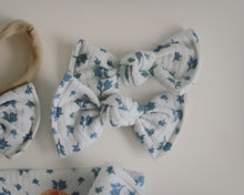 White headbands with blue floral patterns on a light background